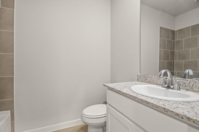 17832 Lionheart Rd, Conroe, TX 77306 - bathroom featuring vanity, toilet, a tub, and baseboards