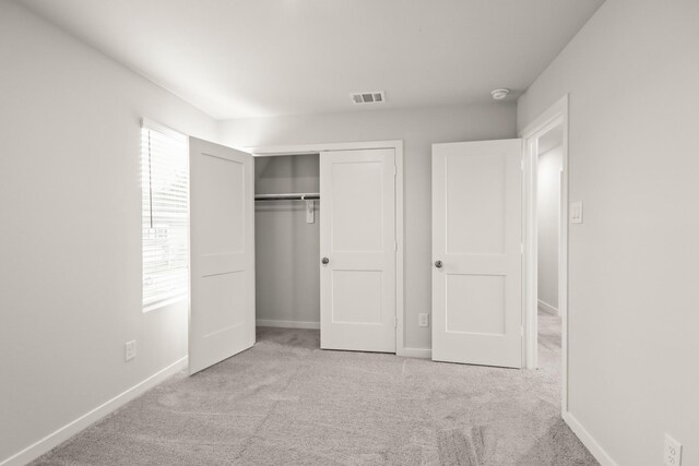 17832 Lionheart Rd, Conroe, TX 77306 - unfurnished bedroom with multiple windows, carpet flooring, a closet, and baseboards