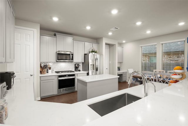 17010 Bainham Forest Trl, Hockley, TX 77447 - kitchen featuring appliances with stainless steel finishes, decorative backsplash, recessed lighting, dark wood finished floors, and a sink