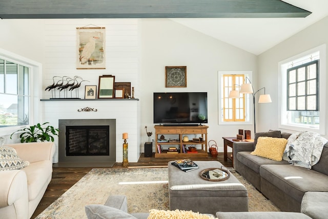 living room featuring vaulted ceiling, dark wood-style floors, and a fireplace