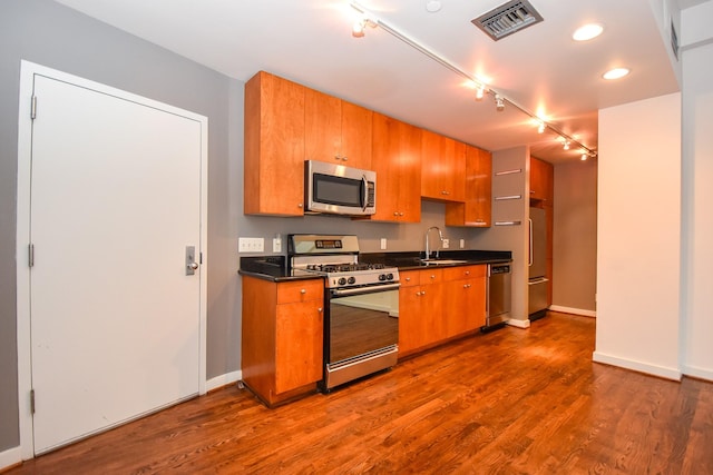 915 Franklin St Unit 4A, Houston, TX 77002 - kitchen with stainless steel appliances, a sink, rail lighting, dark countertops, and recessed lighting