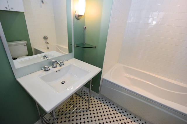 915 Franklin St Unit 4A, Houston, TX 77002 - bathroom featuring a sink, washtub / shower combination, toilet, and baseboards