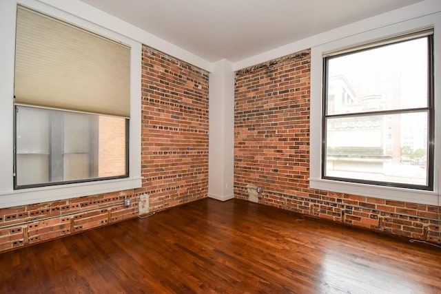 915 Franklin St Unit 4A, Houston, TX 77002 - empty room with brick wall and wood finished floors