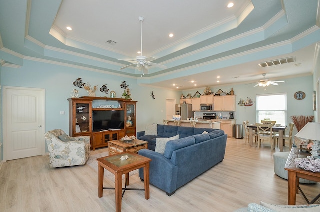 3346 Pirates Cv, Crystal Beach, TX 77650 - living area featuring a tray ceiling, light wood-style floors, visible vents, and ceiling fan