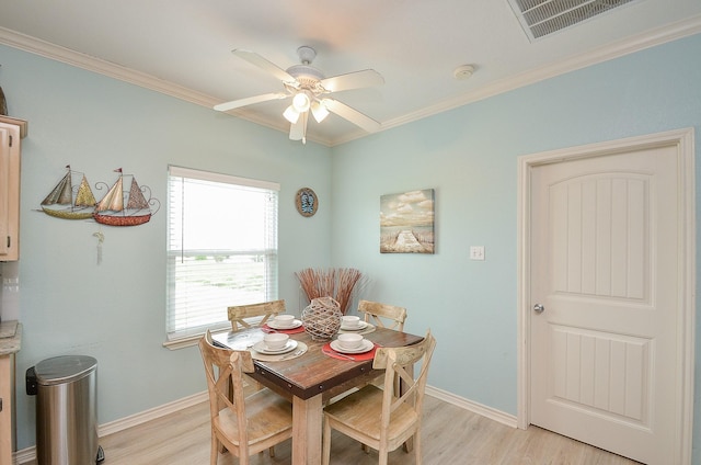 3346 Pirates Cv, Crystal Beach, TX 77650 - dining space featuring light wood-style flooring, crown molding, baseboards, and ceiling fan