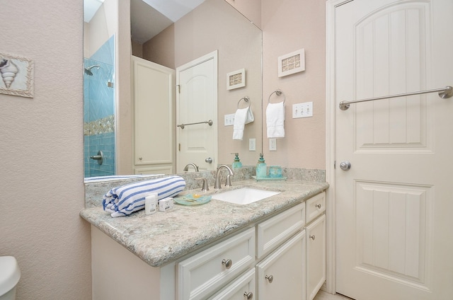 3346 Pirates Cv, Crystal Beach, TX 77650 - bathroom with a textured wall, vanity, and a tile shower
