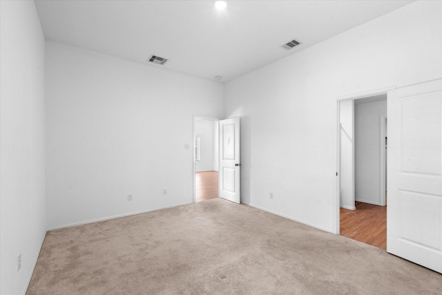 unfurnished bedroom with carpet floors, visible vents, and baseboards