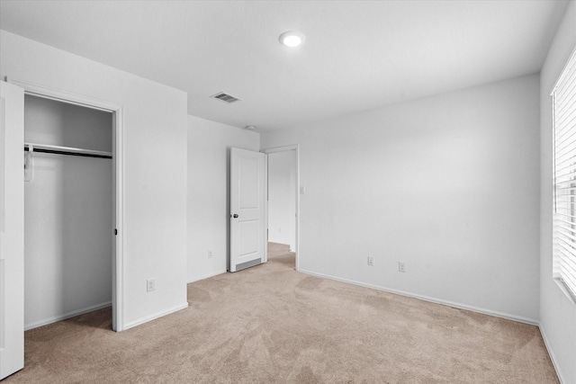 unfurnished bedroom with visible vents, baseboards, and light carpet