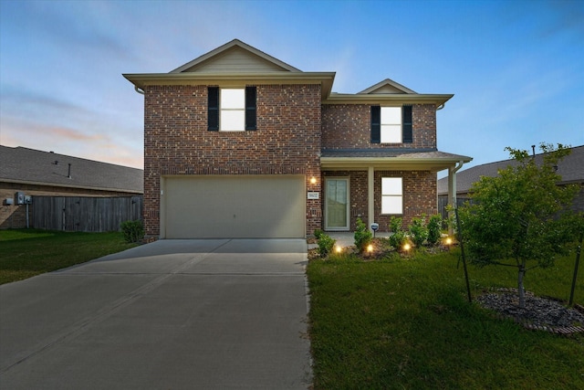 traditional-style home featuring fence, a lawn, driveway, and a garage
