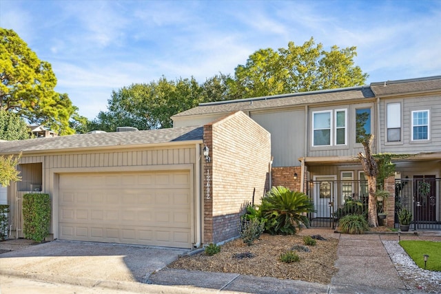 12692 Briar Patch Rd, Houston, TX 77077 - view of property featuring board and batten siding, brick siding, driveway, and a garage