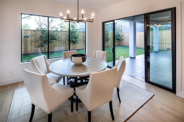 2239 Colquitt St, Houston, TX 77098 - dining area with baseboards, light wood finished floors, a chandelier, and a healthy amount of sunlight