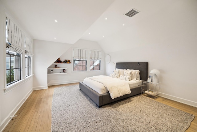 bedroom featuring light wood-type flooring, vaulted ceiling, baseboards, visible vents, and recessed lighting