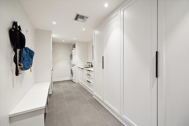 mudroom featuring recessed lighting, stacked washer and clothes dryer, visible vents, and a sink
