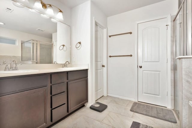 full bathroom with visible vents, a sink, double vanity, and a stall shower