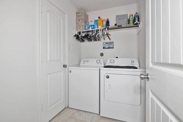 clothes washing area with washer and dryer, laundry area, and light tile patterned floors