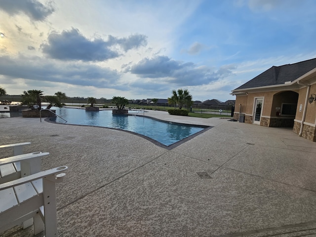 pool with fence and a patio area