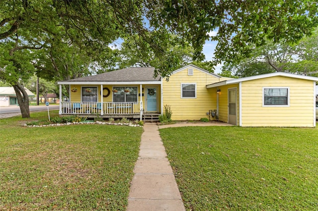 view of front of home with a front lawn, roof with shingles, and a porch