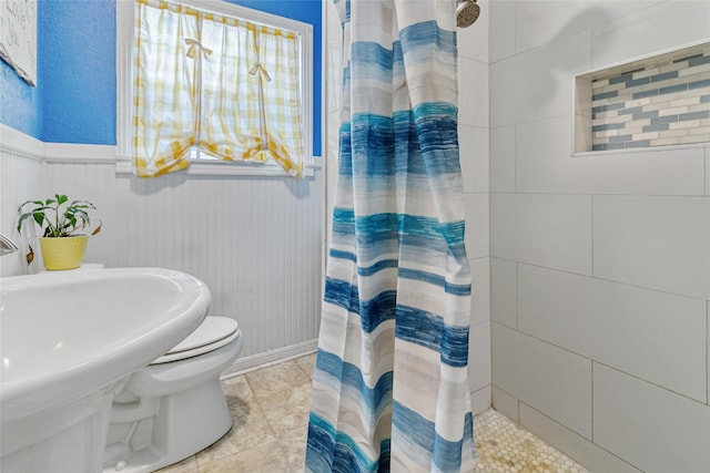 bathroom featuring toilet, a sink, and curtained shower