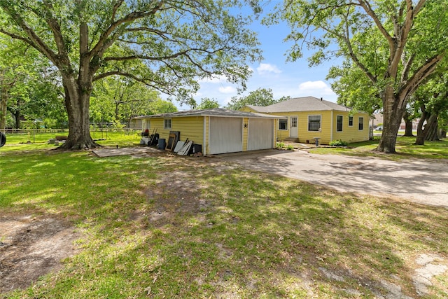 exterior space featuring fence, an outbuilding, and a yard