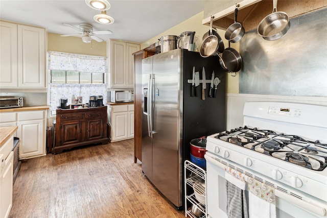 kitchen featuring a toaster, light countertops, a ceiling fan, white appliances, and light wood-style flooring