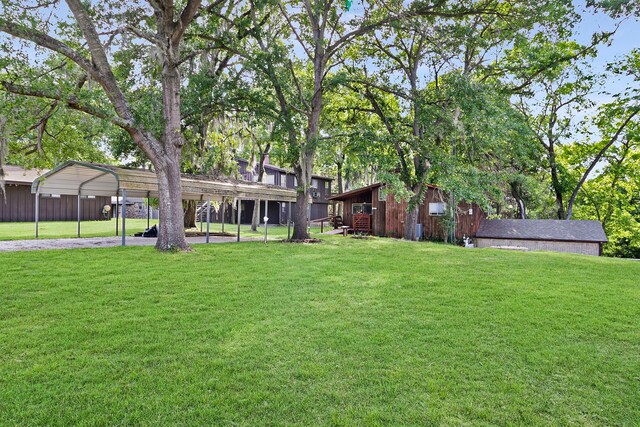 12 Walker Trl, Huntsville, TX 77320 - view of grassy yard with a detached carport, driveway, and an outbuilding