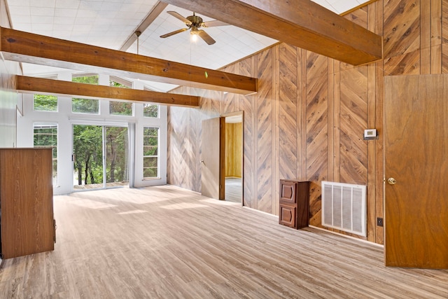12 Walker Trl, Huntsville, TX 77320 - unfurnished living room featuring beamed ceiling, wood walls, high vaulted ceiling, a ceiling fan, and wood finished floors