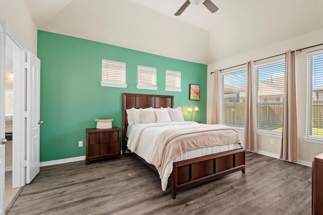 bedroom featuring lofted ceiling, baseboards, and wood finished floors