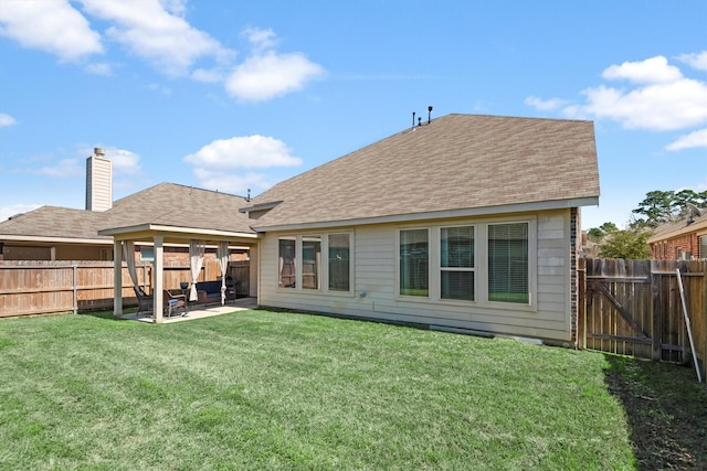 rear view of house featuring a fenced backyard, a yard, a patio area, and a shingled roof