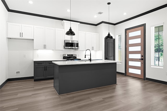 7038 Smilax St A-B, Unit A-B Houston, TX 77088 - kitchen with appliances with stainless steel finishes, light wood-style flooring, crown molding, tasteful backsplash, and a kitchen island with sink