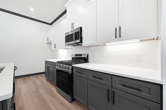 7038 Smilax St A-B, Unit A-B Houston, TX 77088 - kitchen with stainless steel appliances, gray cabinets, decorative backsplash, ornamental molding, and light stone counters