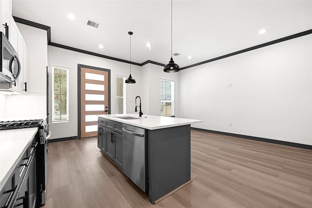 7038 Smilax St A-B, Unit A-B Houston, TX 77088 - kitchen featuring stainless steel appliances, a sink, light wood-type flooring, ornamental molding, and white cabinets