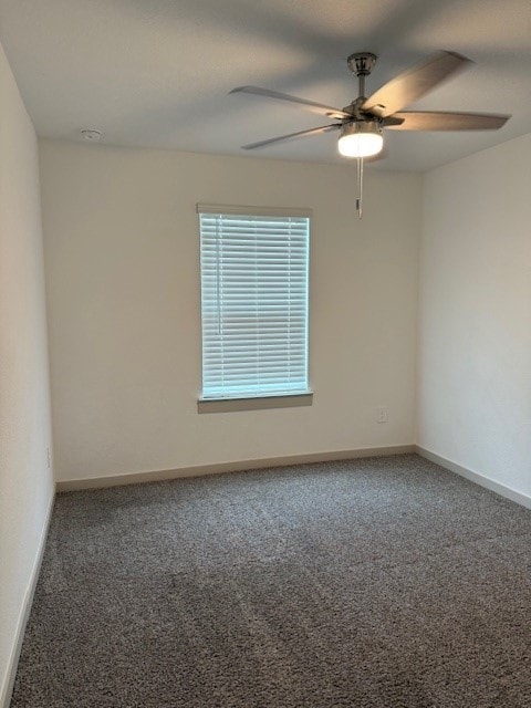 carpeted empty room featuring ceiling fan and baseboards