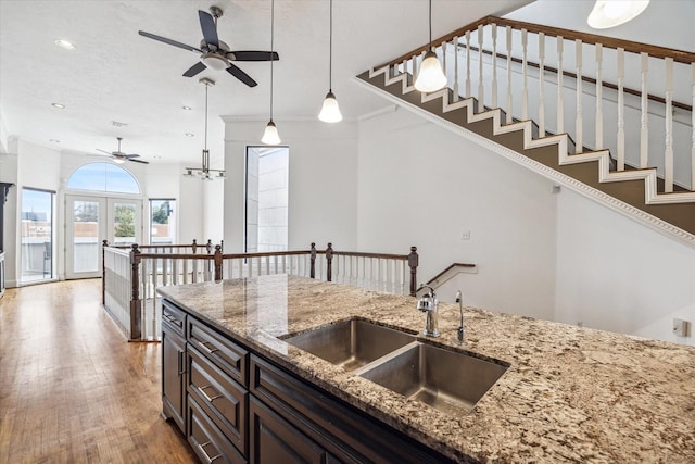 kitchen with a sink, light wood-type flooring, recessed lighting, pendant lighting, and ceiling fan