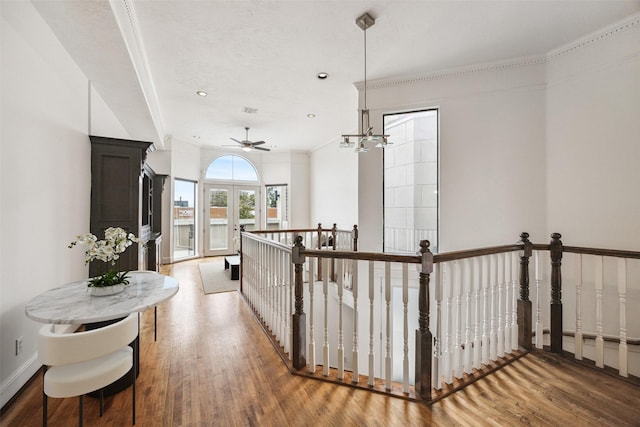 hall featuring baseboards, recessed lighting, a notable chandelier, light wood-style floors, and an upstairs landing