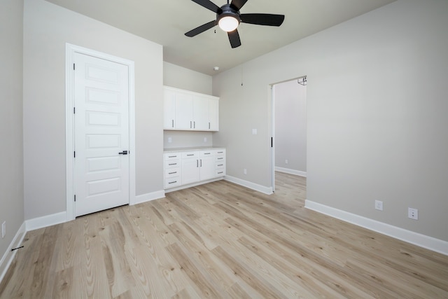 spare room with light wood-style flooring, baseboards, and ceiling fan