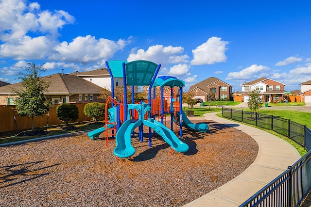 communal playground featuring fence and a residential view