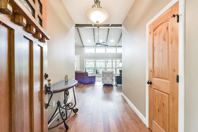 entrance foyer featuring ceiling fan, beam ceiling, wood finished floors, baseboards, and coffered ceiling
