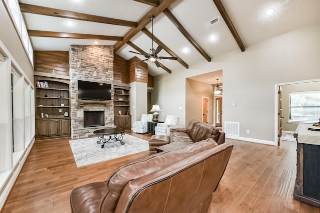 living area with high vaulted ceiling, a fireplace, a ceiling fan, and visible vents