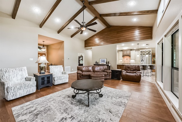 living room with ceiling fan, visible vents, light wood-type flooring, lofted ceiling with beams, and recessed lighting