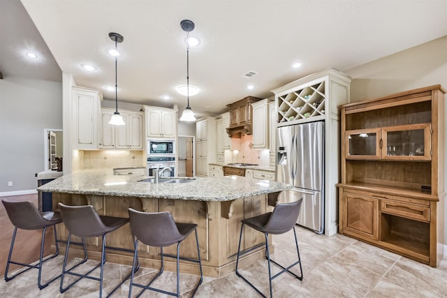kitchen featuring a kitchen bar, visible vents, light stone countertops, a peninsula, and stainless steel appliances