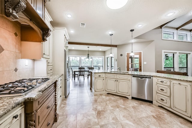 kitchen featuring visible vents, recessed lighting, cream cabinets, a sink, and appliances with stainless steel finishes
