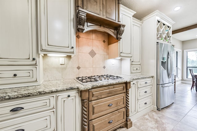 kitchen featuring decorative backsplash, premium range hood, light stone countertops, and stainless steel appliances