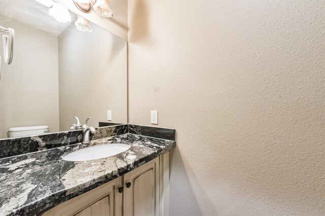 half bathroom with vanity and toilet