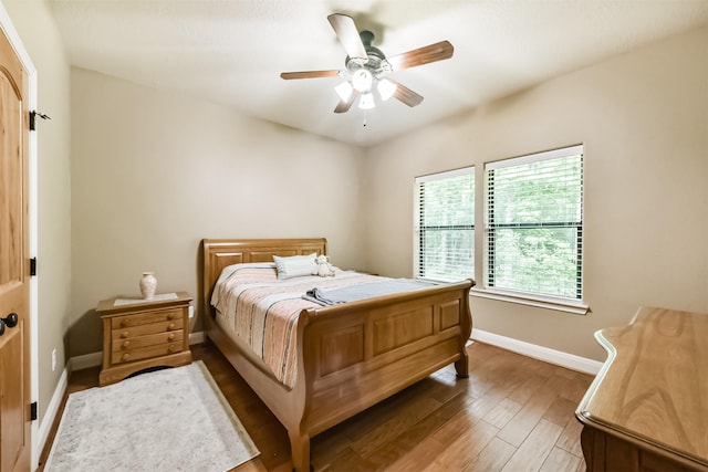 bedroom featuring baseboards, ceiling fan, and wood finished floors
