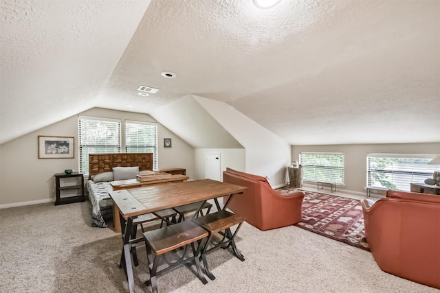 carpeted office with plenty of natural light, lofted ceiling, a textured ceiling, and visible vents