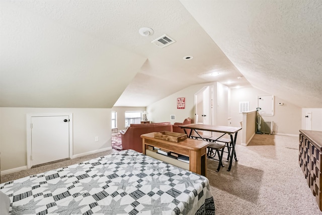 carpeted bedroom featuring baseboards, vaulted ceiling, a textured ceiling, and visible vents