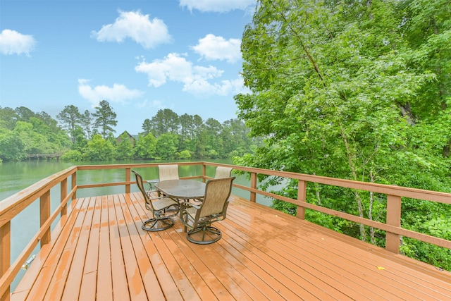 wooden deck featuring a water view and outdoor dining space