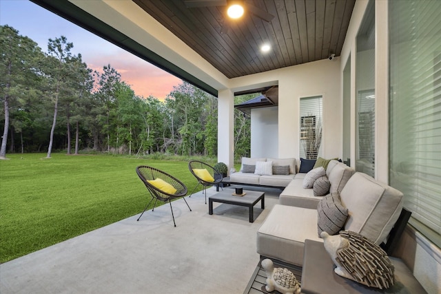 patio terrace at dusk featuring a lawn and outdoor lounge area