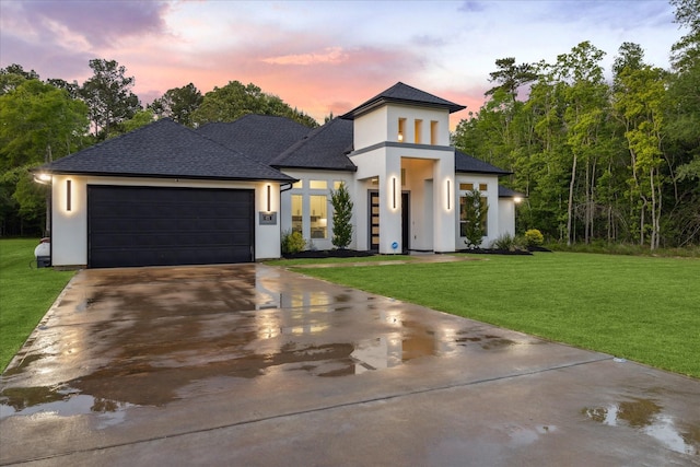 view of front of house with roof with shingles, an attached garage, stucco siding, concrete driveway, and a lawn