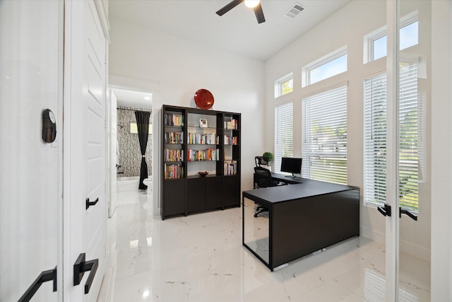 office space featuring a ceiling fan, marble finish floor, and visible vents